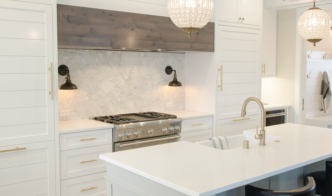 Kuchnia w klasycznym stylu z kinkietami zamontowanymi pod szafkami 