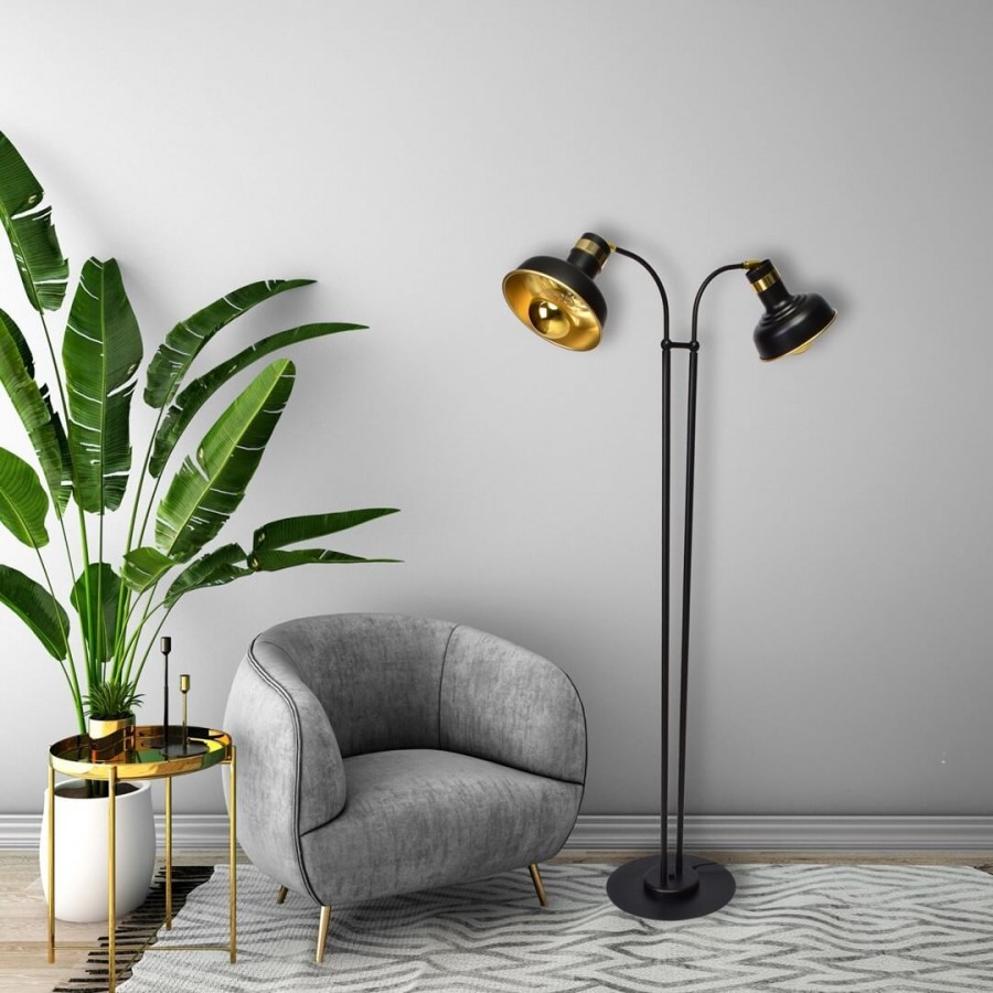 Lampa podłogowa stojąca koło szarego fotela