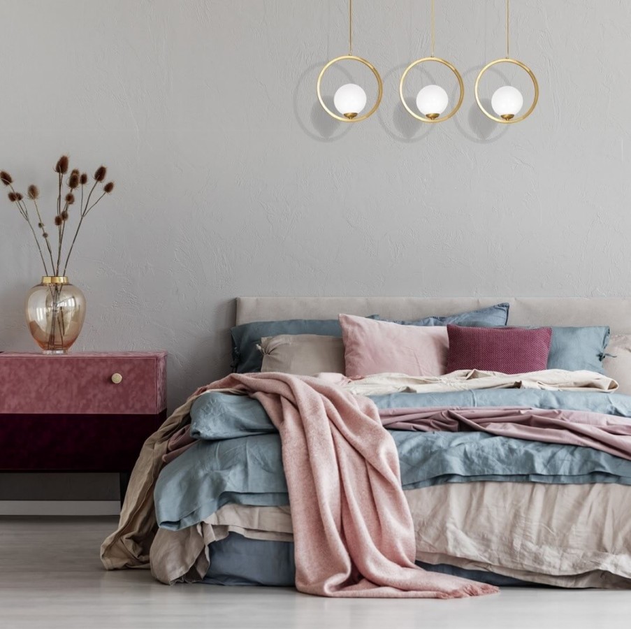 Trzypunktowa szklano-złota lampa obok łóżka