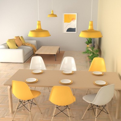 Żółta lampa z kolekcji Enzo zawieszona nad stołem w jadalni i w salonie